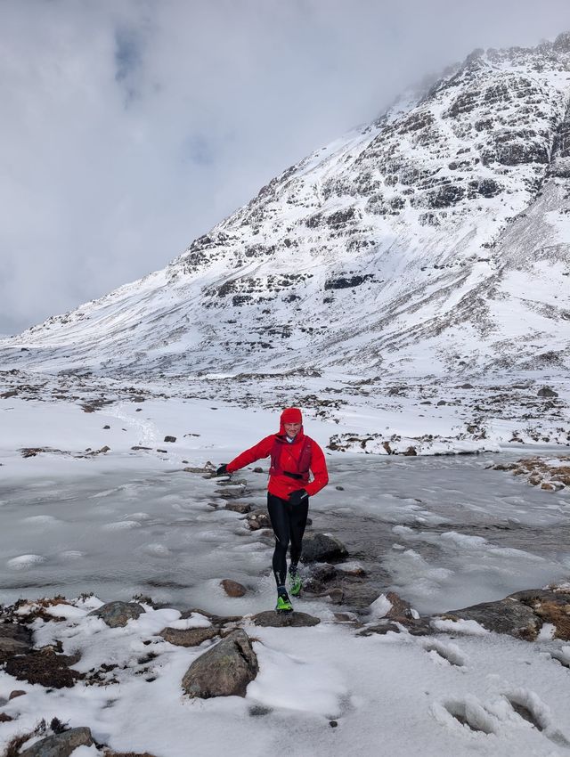 Running across a frozen river beneath a snow-covered mountain